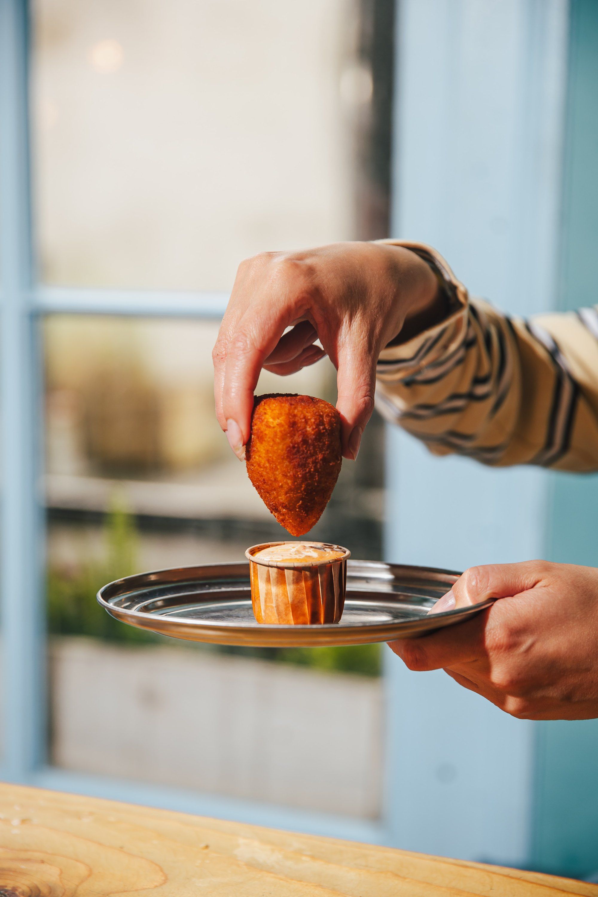 A coxinha dipped in sauce