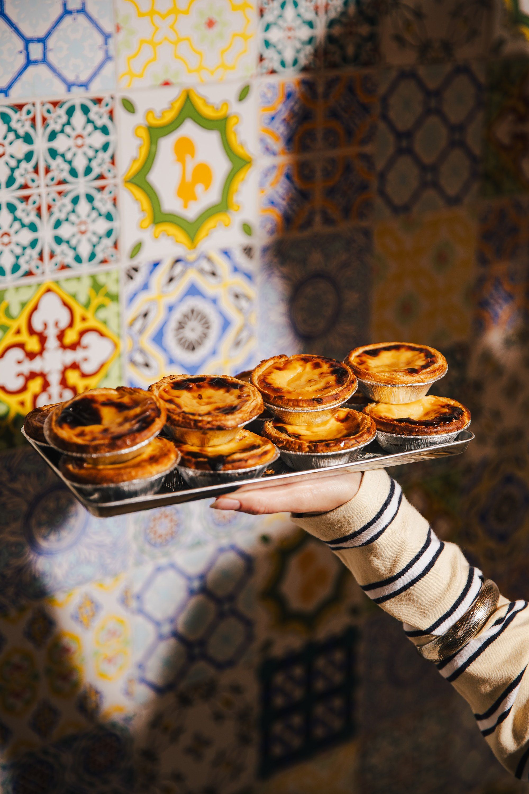 A tray of pastéis de nata against the azulejo tiles