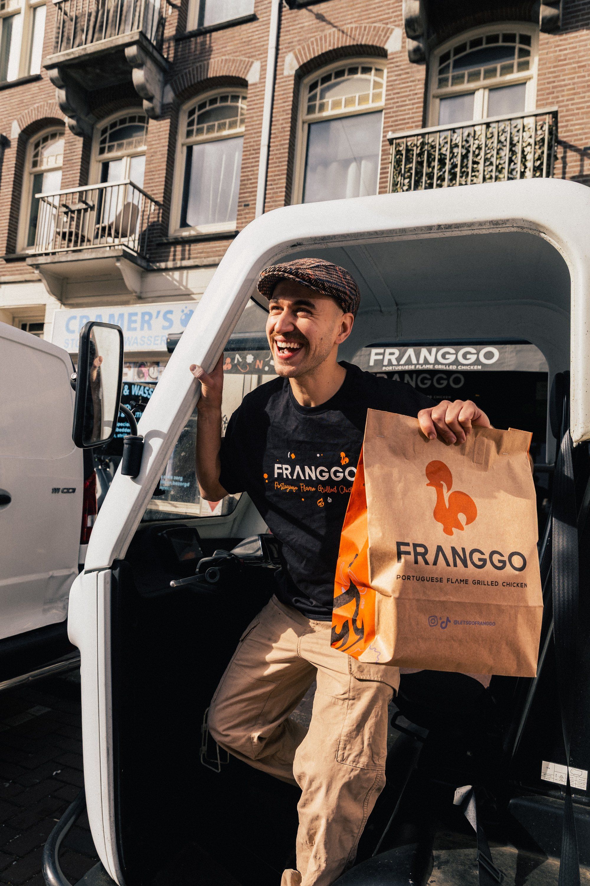 Max in de Franggo-bezorgbus met een Franggo-tas