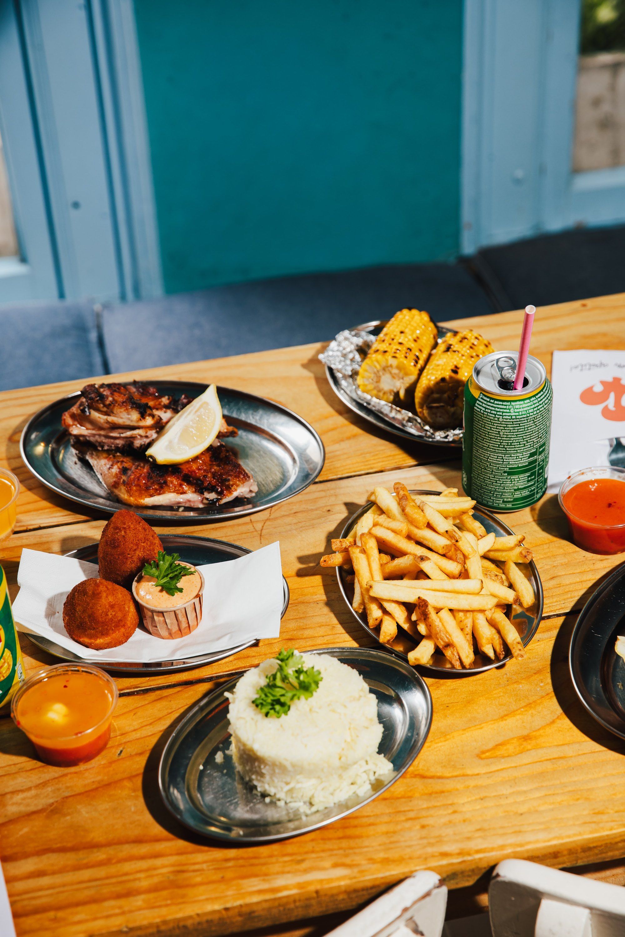 Een gedeelde Franggo-tafel: kip, friet, maïs en coxinhas
