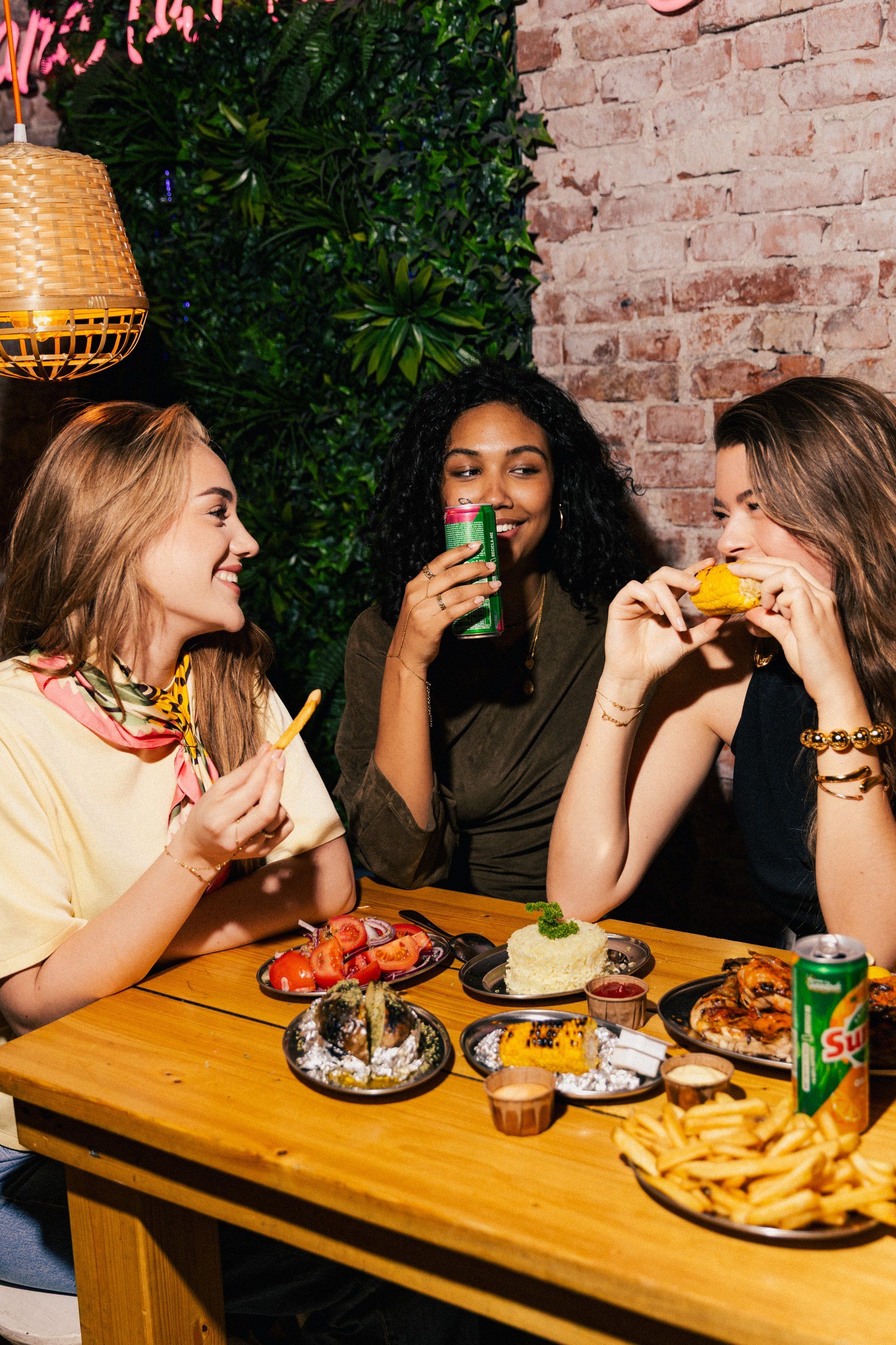 Vriendinnen eten bij Franggo West onder de neon